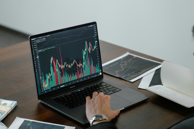 Laptop displaying data analytics dashboards and financial charts on an office desk.